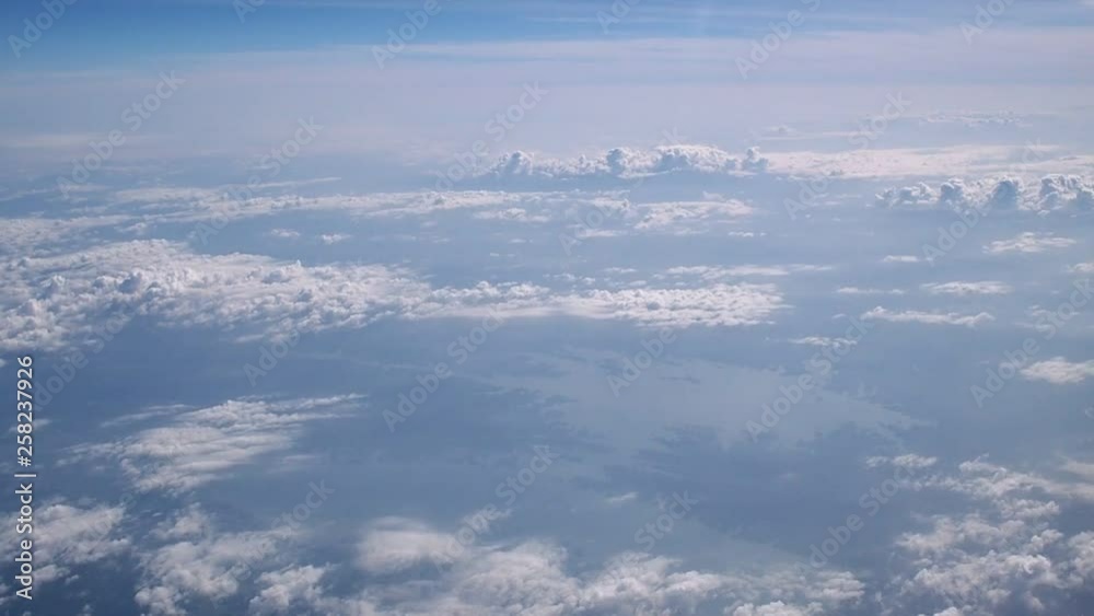 Above the clouds, flying in the air. View of clouds through airplane window. Above the clouds, flying in the air. View of clouds through airplane window.