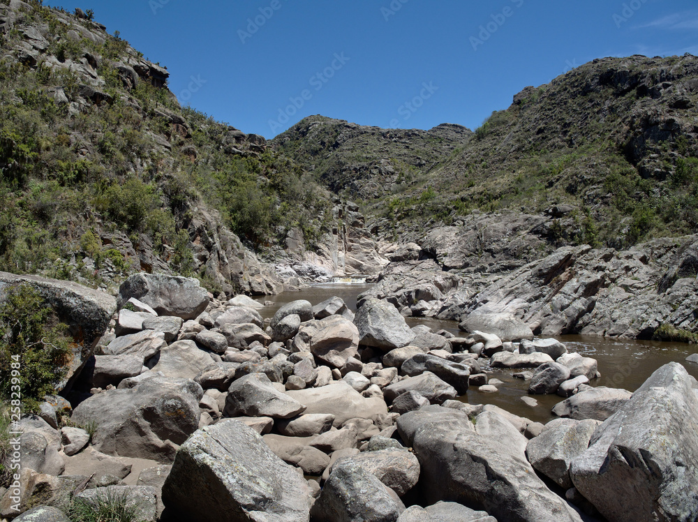 View of the Yuspe river running through the mountains at Cerro Blanco reserve, near Tanti and Los Gigantes, Cordoba, Argentina View of the Yuspe river running through the mountains at Cerro Blanco reserve, near Tanti and Los Gigantes, Cordoba, Argentina