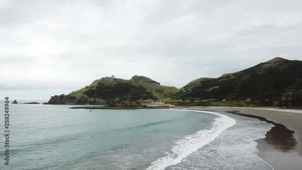 Aerial shot, tracking a sea legs from ocean onto the road, [flying low into the boat] Great Barrier Island, New Zealand