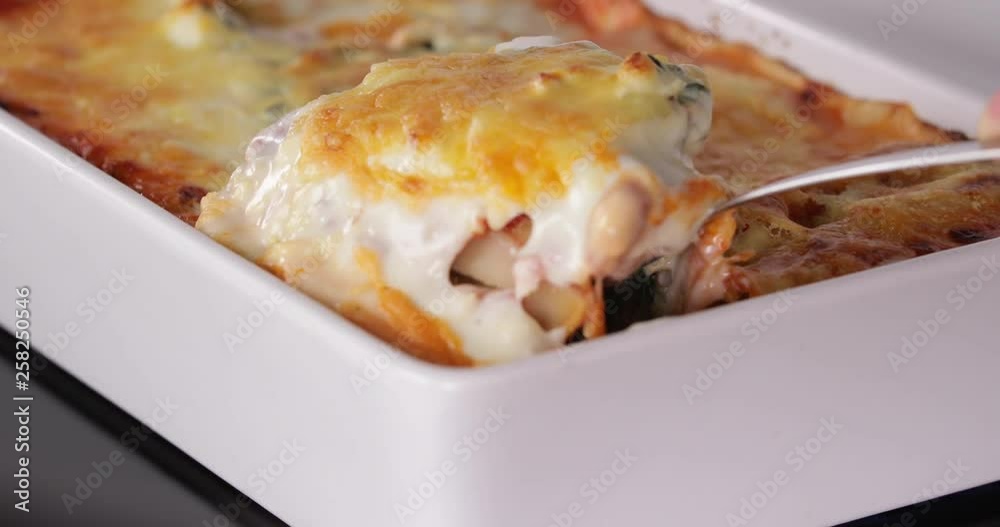 Closeup of Lady taking a serving spoon of Spinach and ricotta cannelloni hot from the oven dish 30 fps 4K IN REVERSE Closeup of Lady taking a serving spoon of Spinach and ricotta cannelloni hot from the oven dish 30 fps 4K IN REVERSE