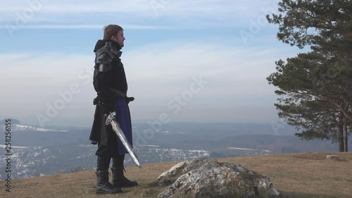 Soldier drawing sword on mountain photo