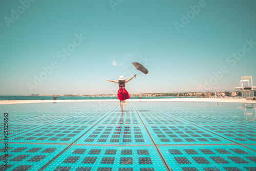Happy woman traveler dances on outdoor disco floor in Zadar, Croatia. photo