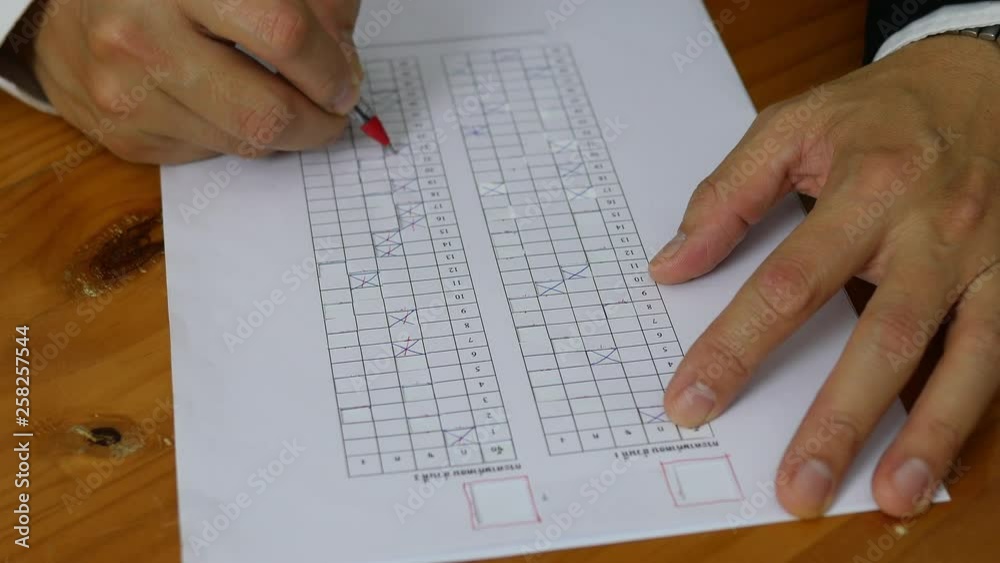 Teacher is checking multiple choices examination answer sheet - education activity concept Teacher is checking multiple choices examination answer sheet - education activity concept