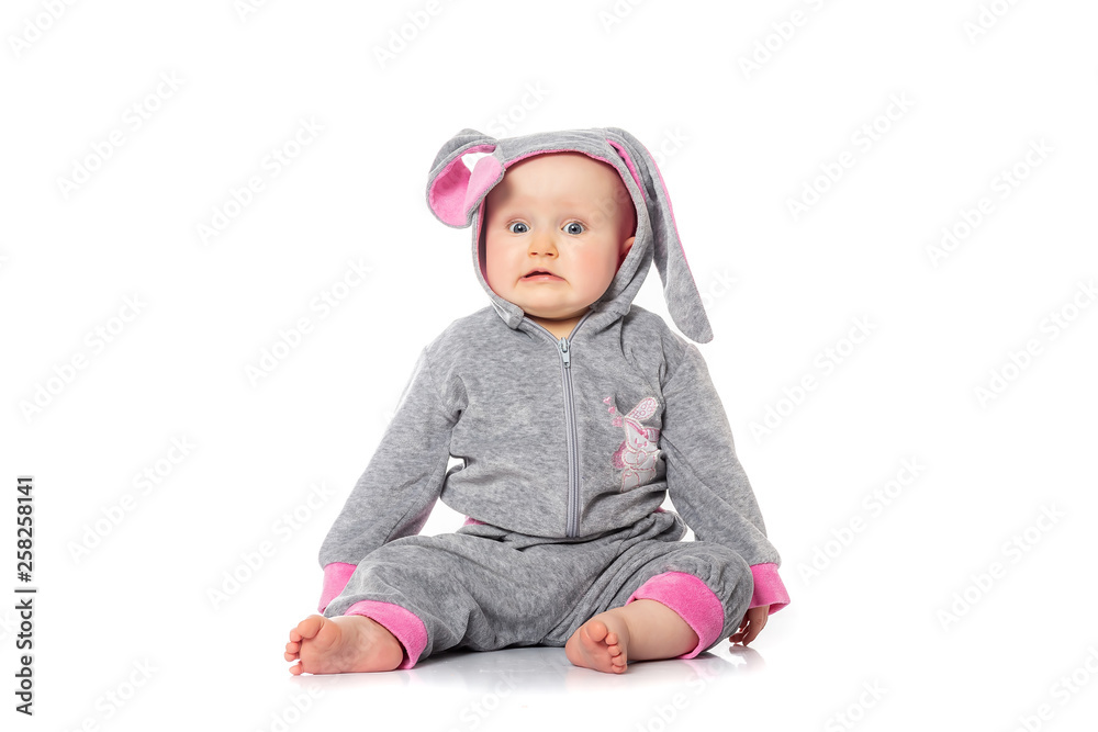 Cute little baby in bunny costume sitting on white background. breakfast on Easter morning. Kids celebrating Easter. baby emotions Cute little baby in bunny costume sitting on white background. breakfast on Easter morning. Kids celebrating Easter. baby emotions