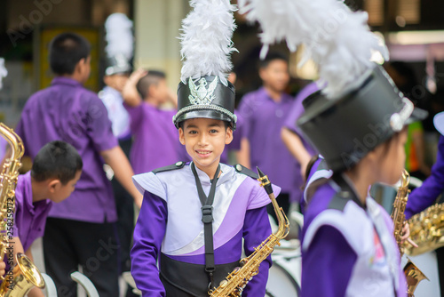 Little boy in purple white uniform play saxophone in  marching band