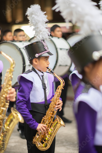 Canvastavla Little boy in purple white uniform play saxophone in  marching band