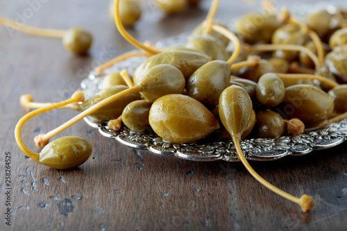 Фотография Pickled caper berries in metal dish .