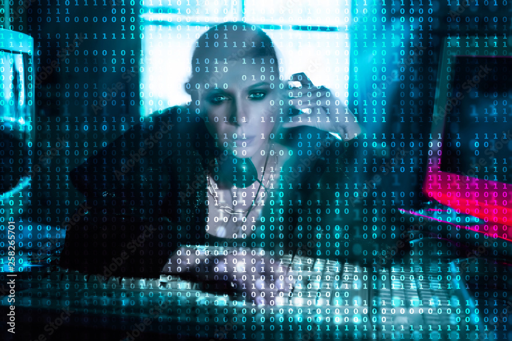 Female hacker at the computer over code background Female hacker at the computer over code background