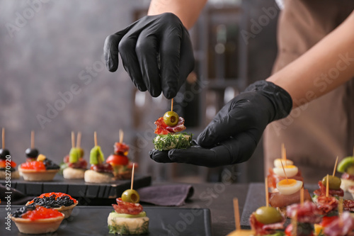 Chef preparing tasty canapes for serving photo