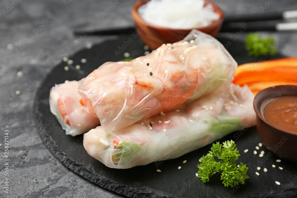 Tasty spring rolls on slate plate, closeup Tasty spring rolls on slate plate, closeup