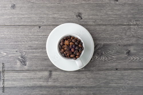 Coffee cup and coffee beans on wooden background. Top view and selective focus