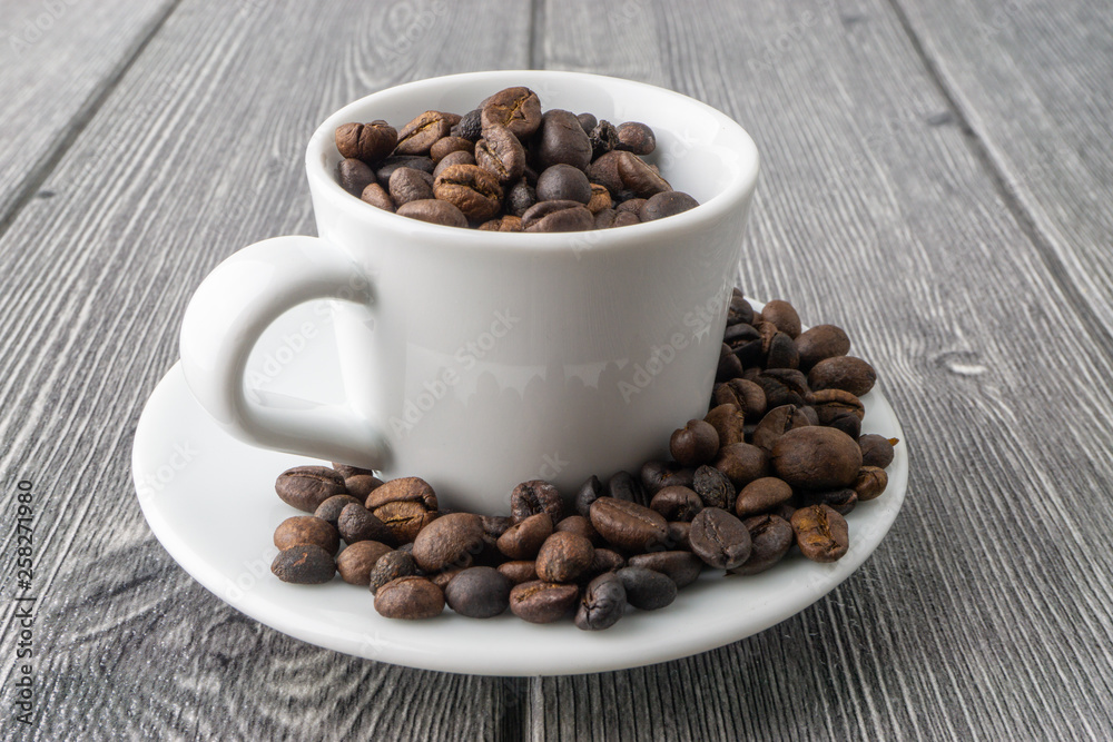 Coffee cup and coffee beans on wooden background. Top view and selective focus Coffee cup and coffee beans on wooden background. Top view and selective focus