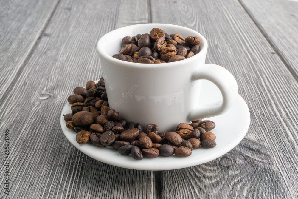 Coffee cup and coffee beans on wooden background. Top view and selective focus Coffee cup and coffee beans on wooden background. Top view and selective focus