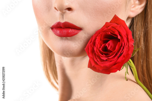 Beautiful young woman with bright makeup and flower on white background  closeup