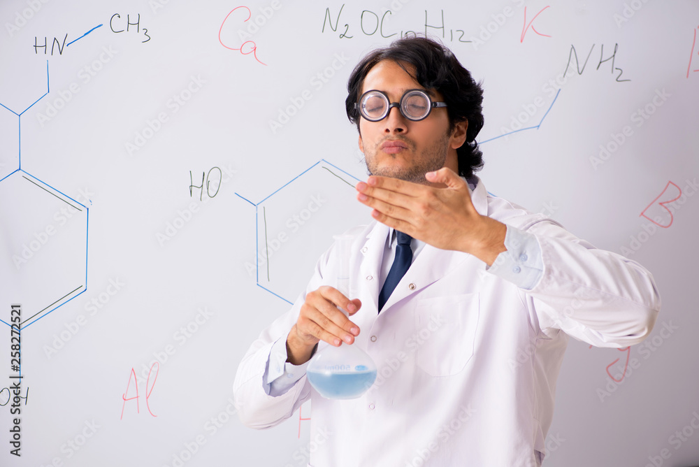 Young funny chemist in front of white board Young funny chemist in front of white board