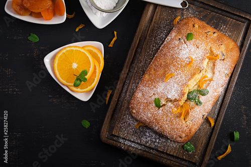 Tableau sur Toile Orange cake with dried apricots and powdered sugar. Top view