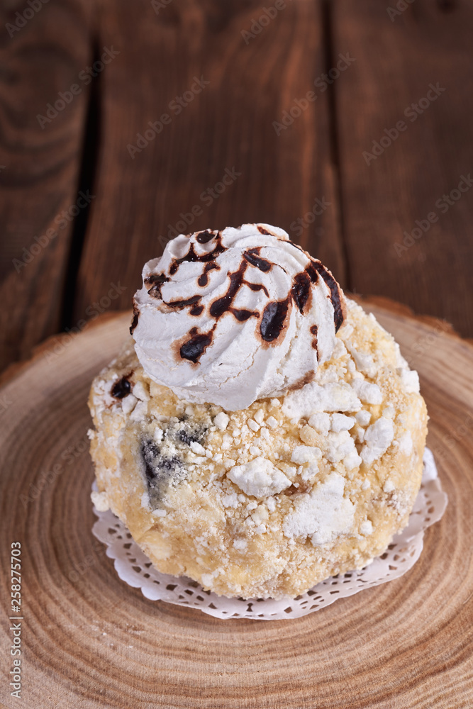 Airy dessert with meringue in chocolate drops with prunes and butter cream in a wooden stand on a wooden background. Close-up Airy dessert with meringue in chocolate drops with prunes and butter cream in a wooden stand on a wooden background. Close-up