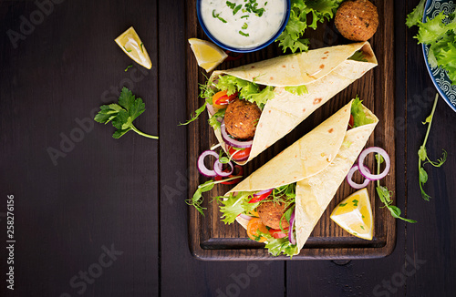 Tortilla wrap with falafel and fresh salad. Vegan tacos. Vegetarian healthy food. Top view photo