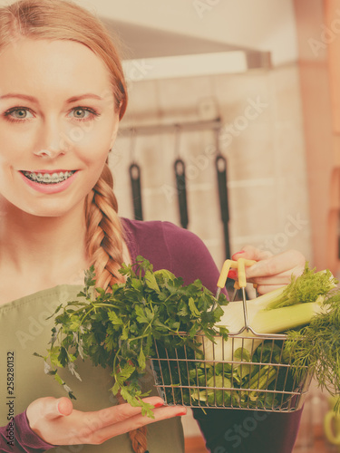 Woman in kitchen having vegetables holding shopping basket