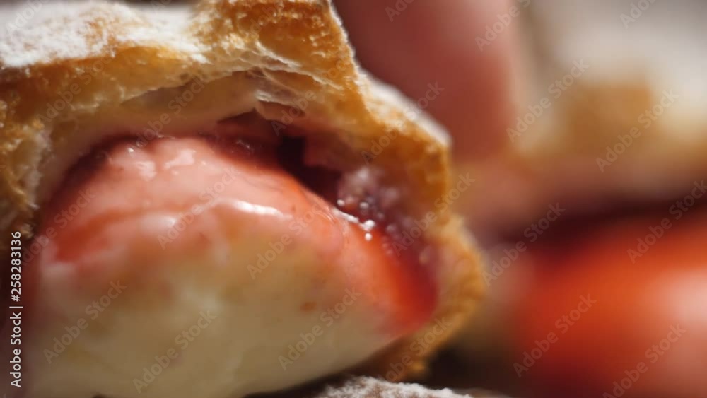 fresh homemade eclairs sprinkled with powdered sugar with red and white custard in 4K slow motion close up video fresh homemade eclairs sprinkled with powdered sugar with red and white custard in 4K slow motion close up video