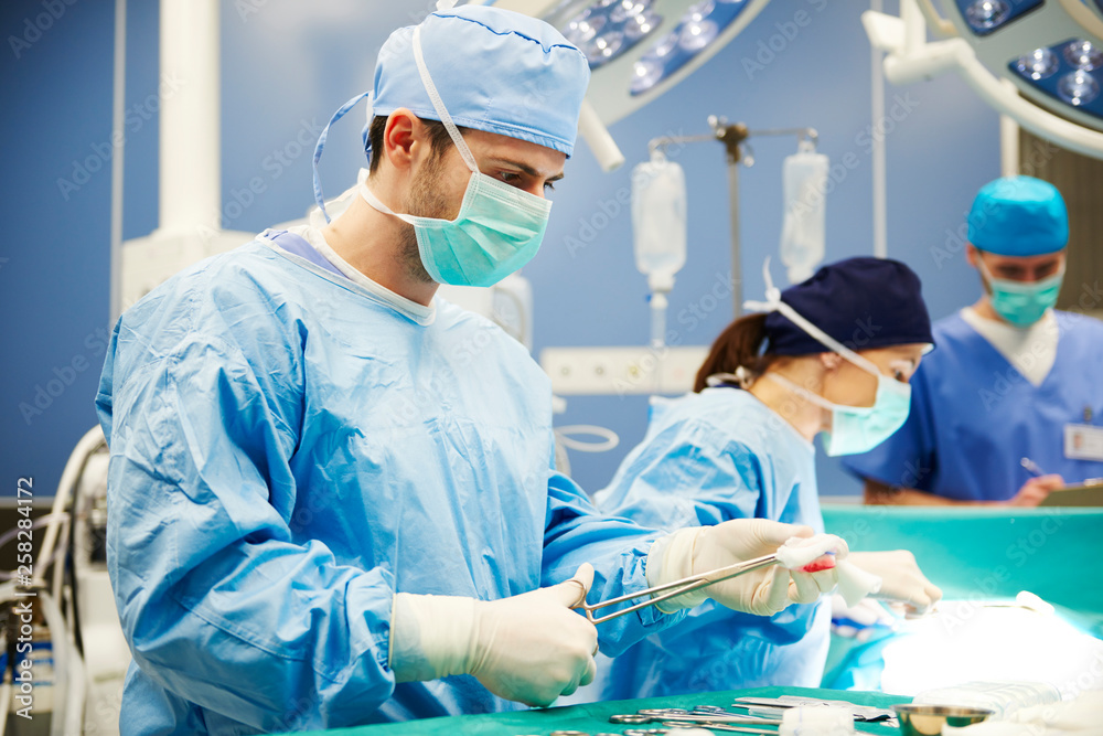 Surgeon using medical scissors while an operation Surgeon using medical scissors while an operation