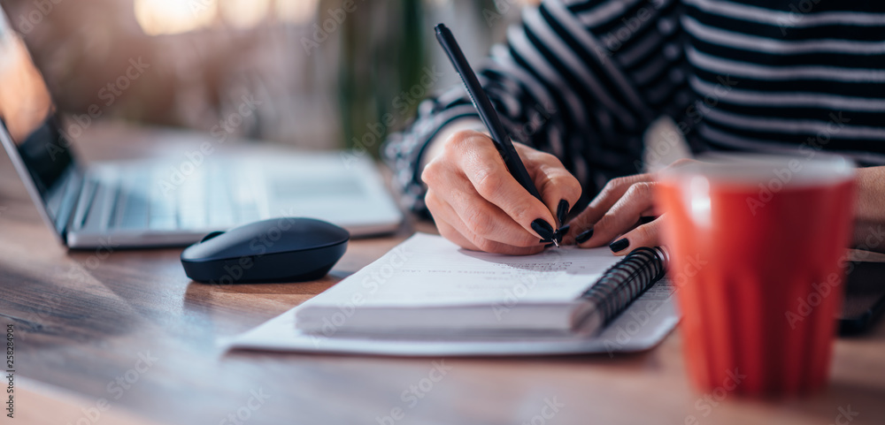 Woman writing notes in notebook Woman writing notes in notebook