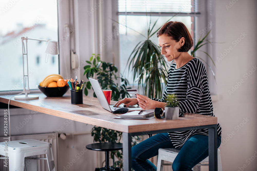 Woman shopping online and using credit card Woman shopping online and using credit card