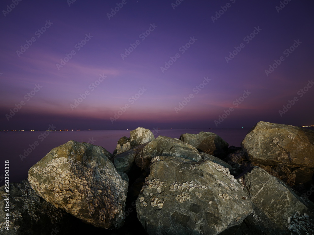 Ocean water rushing by a rock on twilight time. Ocean water rushing by a rock on twilight time.