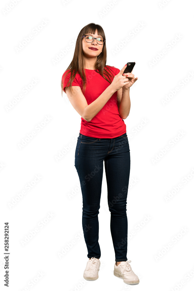 Full-length shot of Woman with glasses sending a message with the mobile Full-length shot of Woman with glasses sending a message with the mobile