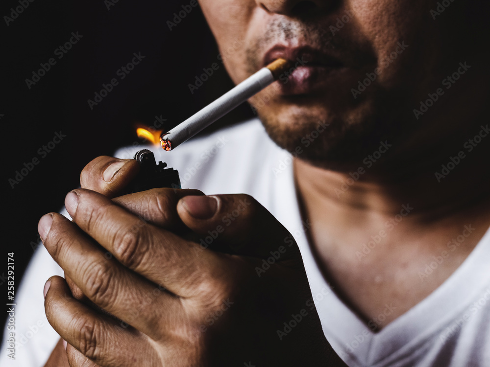 Fototapeta premium Man smoking cigarette.concepts of medical marijuana use and legalization of the cannabis. On a black background