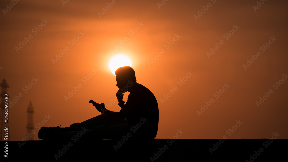 silhouette of man thinking in sunset