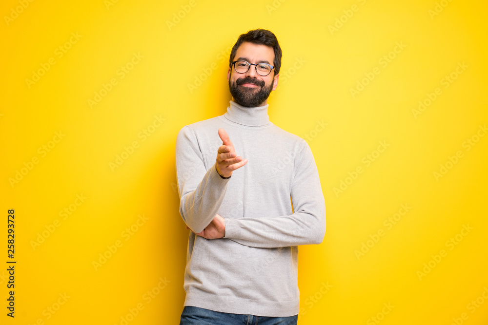 Man with beard and turtleneck shaking hands for closing a good deal Man with beard and turtleneck shaking hands for closing a good deal