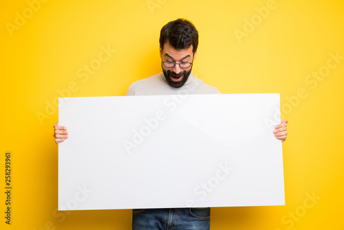 Man with beard and turtleneck holding a placard for insert a concept