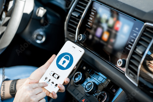 Close-up of a smart phone with car alarm application, controlling a vehicle in the car photo