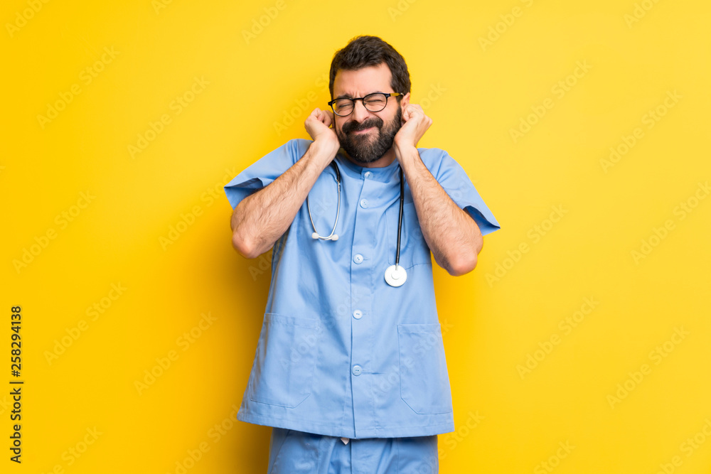 Surgeon doctor man covering ears with hands. Frustrated expression Surgeon doctor man covering ears with hands. Frustrated expression