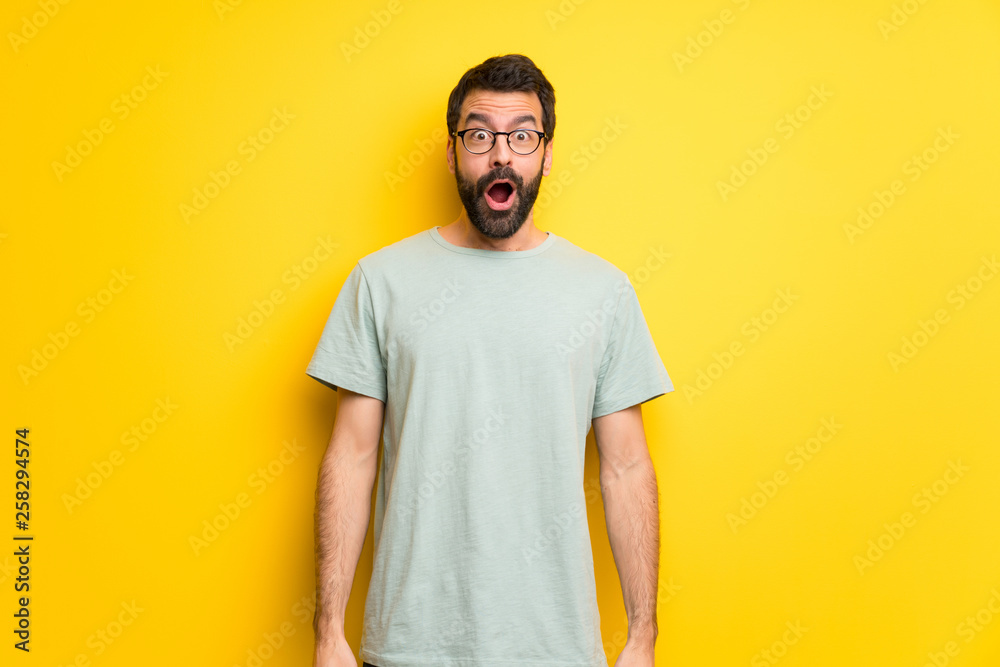 Man with beard and green shirt with surprise and shocked facial expression Man with beard and green shirt with surprise and shocked facial expression