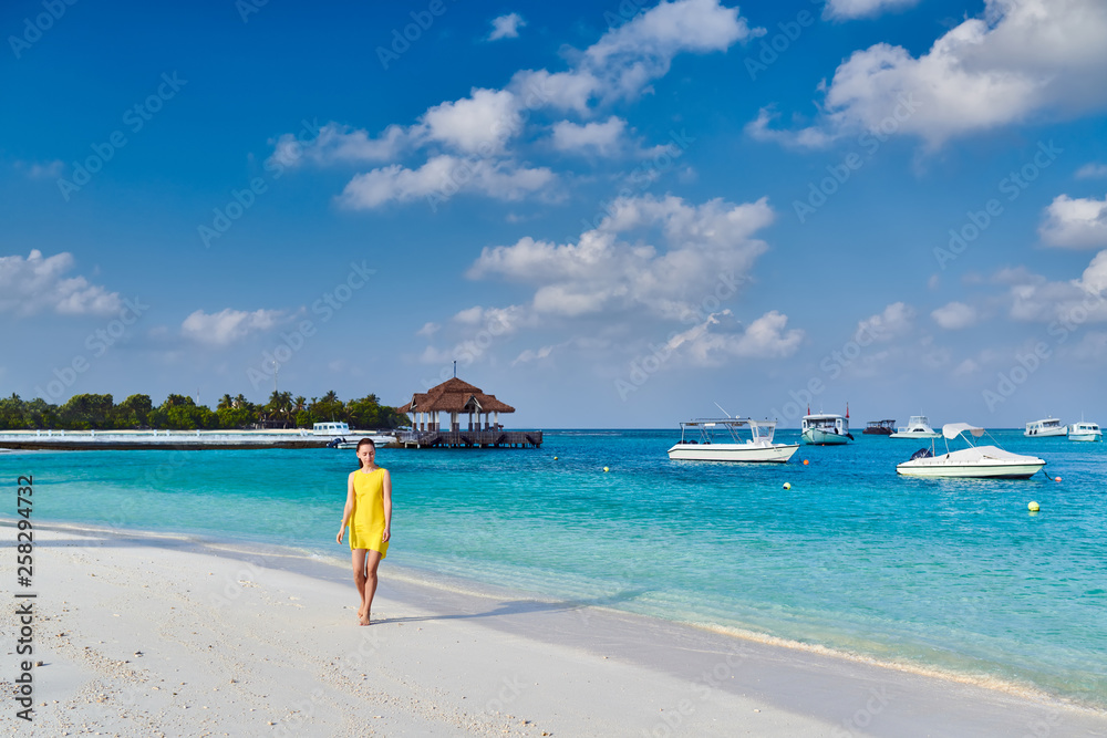 Woman in dress walking on tropical beach