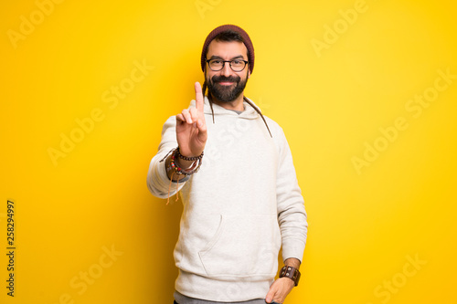 Hippie man with dreadlocks showing and lifting a finger