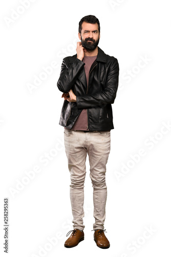 Handsome man with beard having doubts over isolated white background