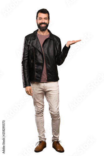 Handsome man with beard holding copyspace imaginary on the palm to insert an ad over isolated white background