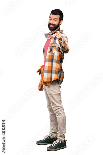 Craftsmen man points finger at you with a confident expression over isolated white background