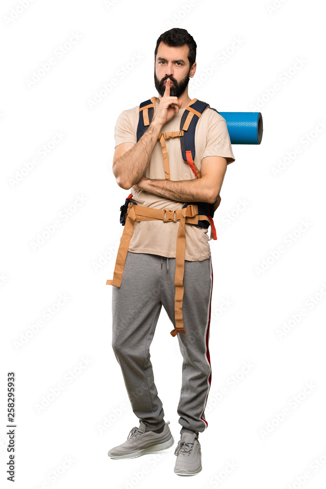 Hiker man showing a sign of silence gesture putting finger in mouth over isolated white background Hiker man showing a sign of silence gesture putting finger in mouth over isolated white background