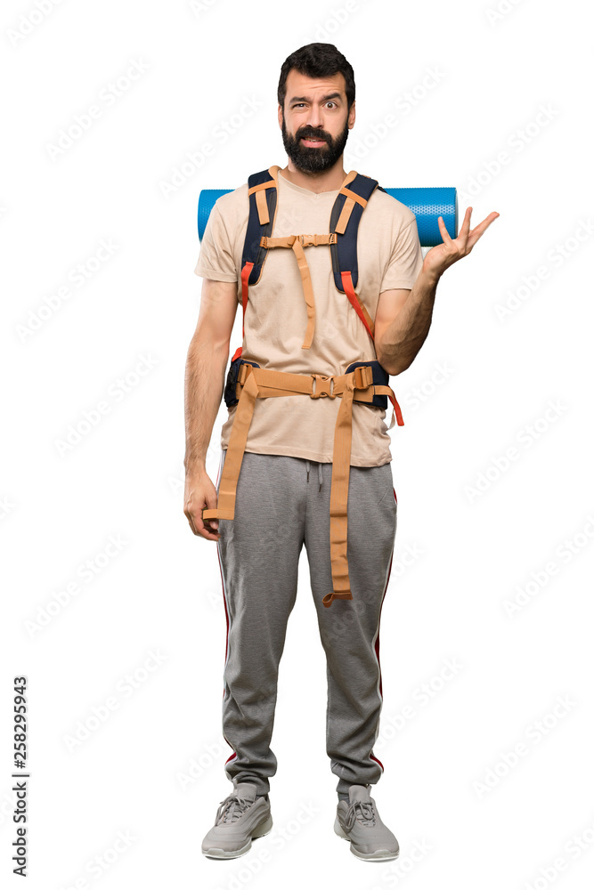 Hiker man making doubts gesture over isolated white background Hiker man making doubts gesture over isolated white background