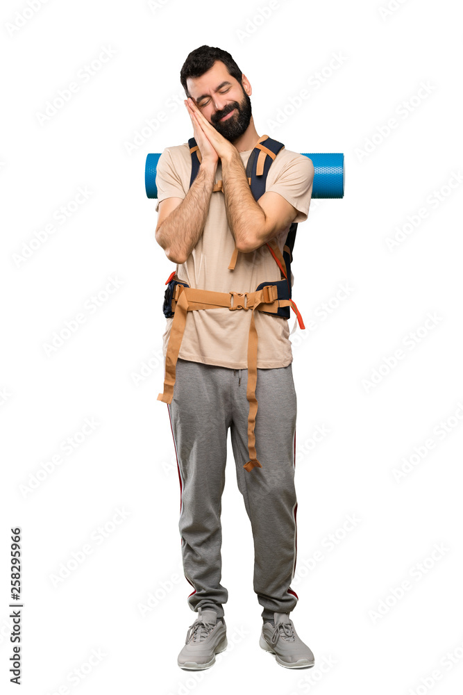 Hiker man making sleep gesture in dorable expression over isolated white background Hiker man making sleep gesture in dorable expression over isolated white background