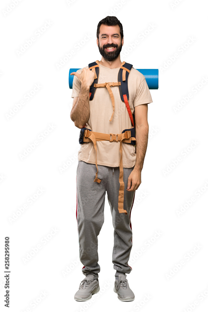 Hiker man pointing to the side to present a product over isolated white background Hiker man pointing to the side to present a product over isolated white background