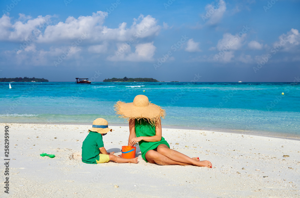 Woman in green dress with three year old boy on beach Woman in green dress with three year old boy on beach