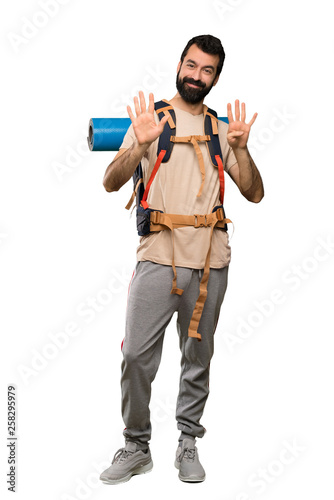 Hiker man counting nine with fingers over isolated white background