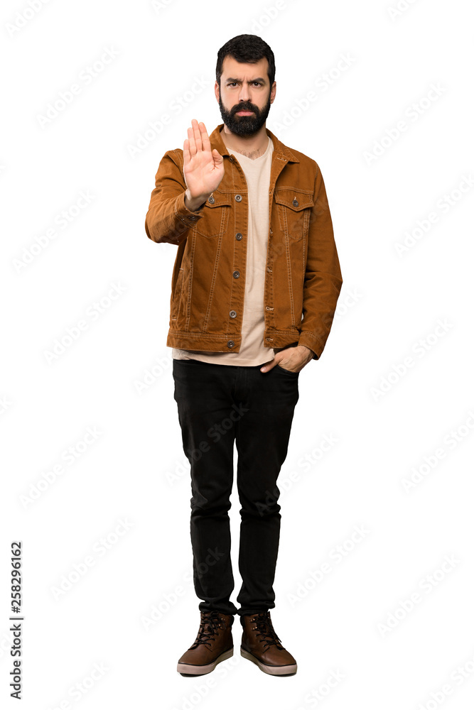 Handsome man with beard making stop gesture over isolated white background Handsome man with beard making stop gesture over isolated white background