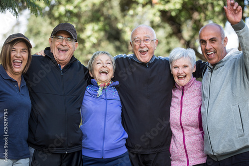 Gruppo di anziani signori vestiti in tuta si gode la vita al parco photo