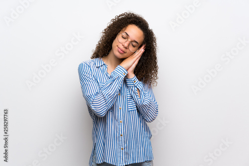 Dominican woman with striped shirt making sleep gesture in dorable expression © luismolinero